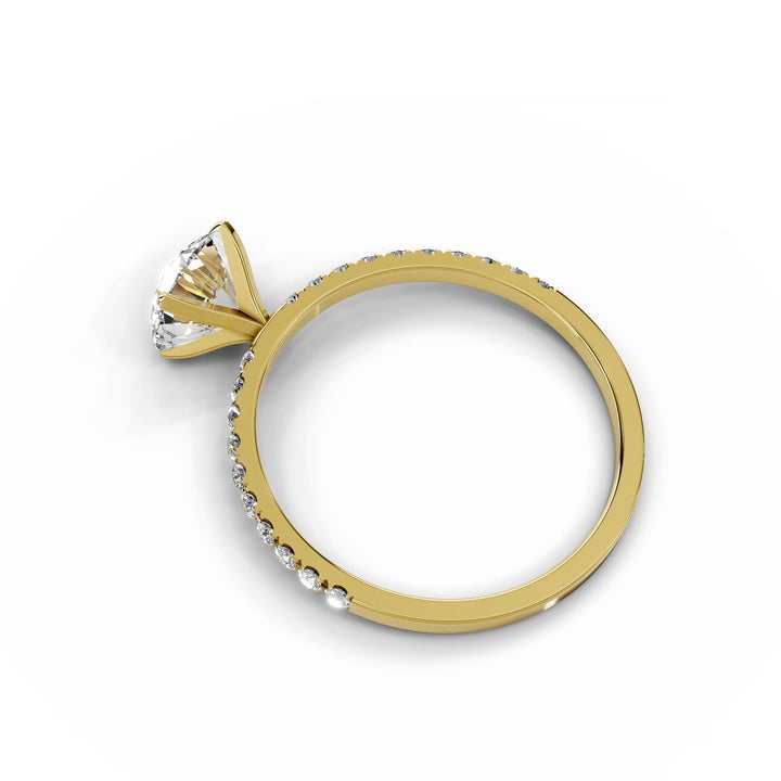 Round diamond pavé engagement ring in yellow gold.