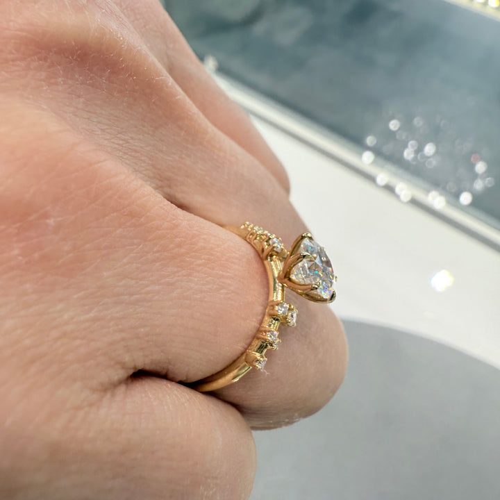 1 Ct round moissanite engagement ring with accent stones in 14K gold.