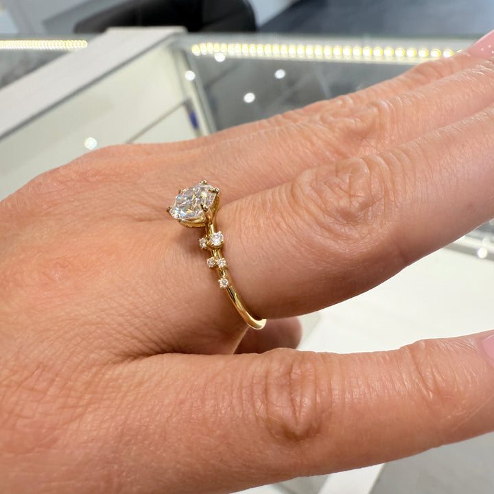 1 Ct round moissanite engagement ring with accent stones in 14K gold.