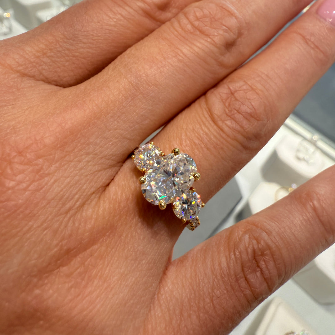 2 Ct oval moissanite three-stone engagement ring with side stones in 14K gold.
