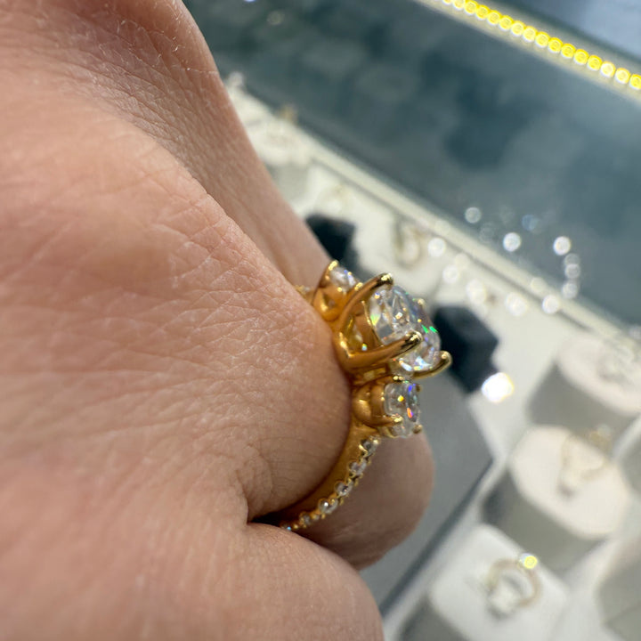 2 Ct oval moissanite three-stone engagement ring with side stones in 14K gold.