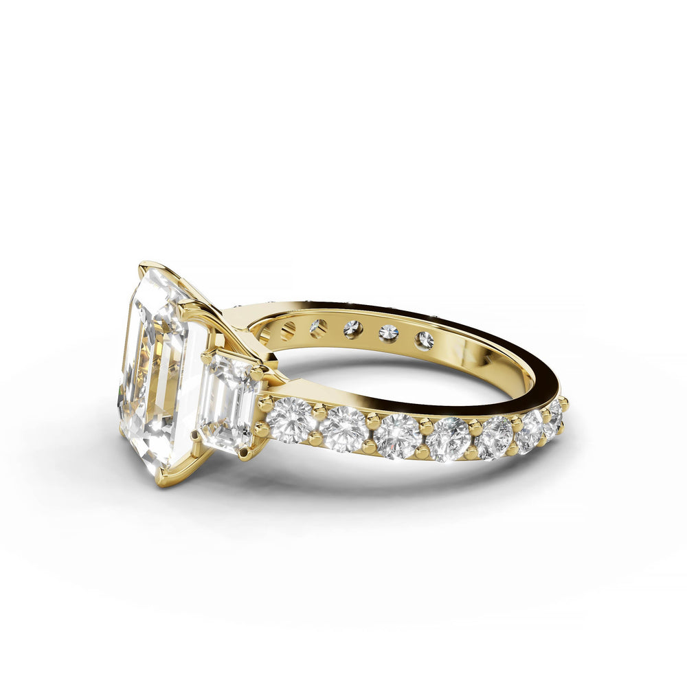 Emerald cut diamond three-stone engagement ring in yellow gold.