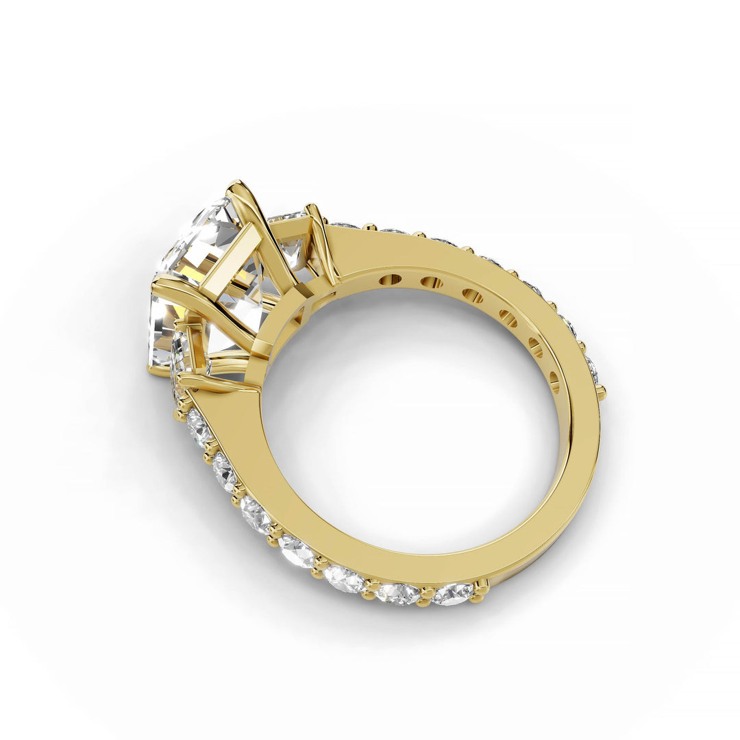 Emerald cut diamond three-stone engagement ring in yellow gold.