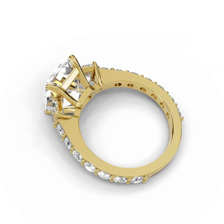 Emerald cut diamond three-stone engagement ring in yellow gold.