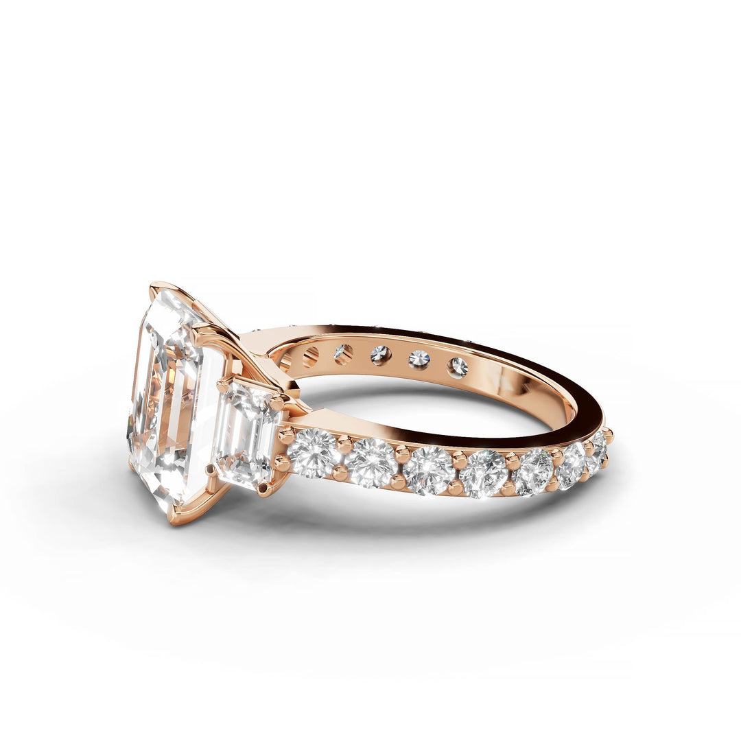 Emerald cut diamond engagement ring with three stones in rose gold.