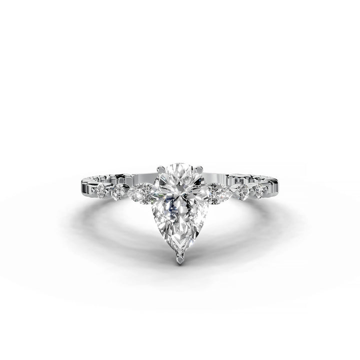 Pear-shaped diamond engagement ring, three-stone style, white gold band, geometric pattern.