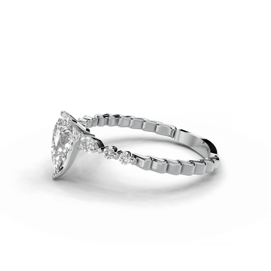 Pear-shaped diamond engagement ring, three-stone style, white gold band, geometric pattern.
