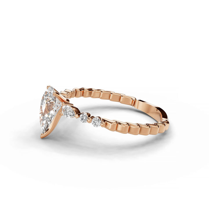 Pear-shaped diamond engagement ring, three-stone style, rose gold band.