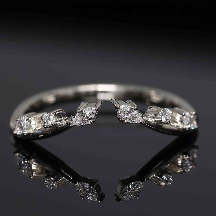Curved wedding band with lab-grown round and marquise diamonds in shared prongs, open design.