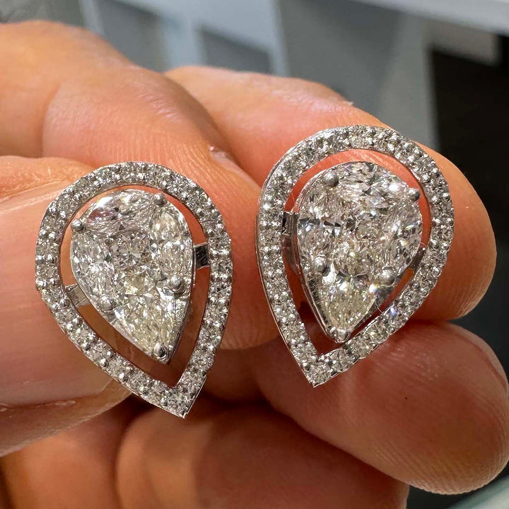 Close-up of elegant 10K white gold halo jacket earrings featuring an illusion pear-shaped centerpiece made from small marquise and pear-shaped lab-grown diamonds, totaling 1.62 carats, set in a pavé setting that enhances the sparkle and illusion of a single large pear-shaped diamond.