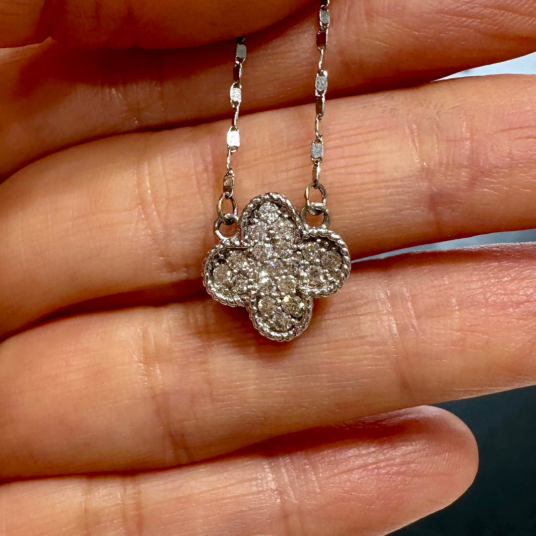 Close-up of a 14K white gold cluster necklace with 0.55ct lab diamonds in a four-leaf clover design.