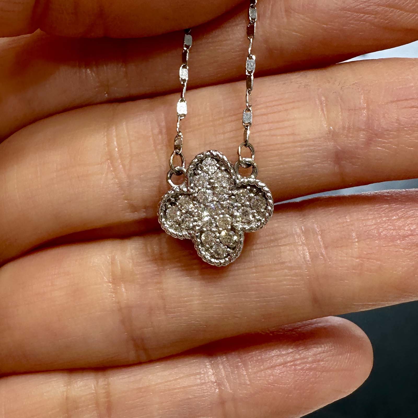 Close-up of a 14K white gold cluster necklace with 0.55ct lab diamonds in a four-leaf clover design.