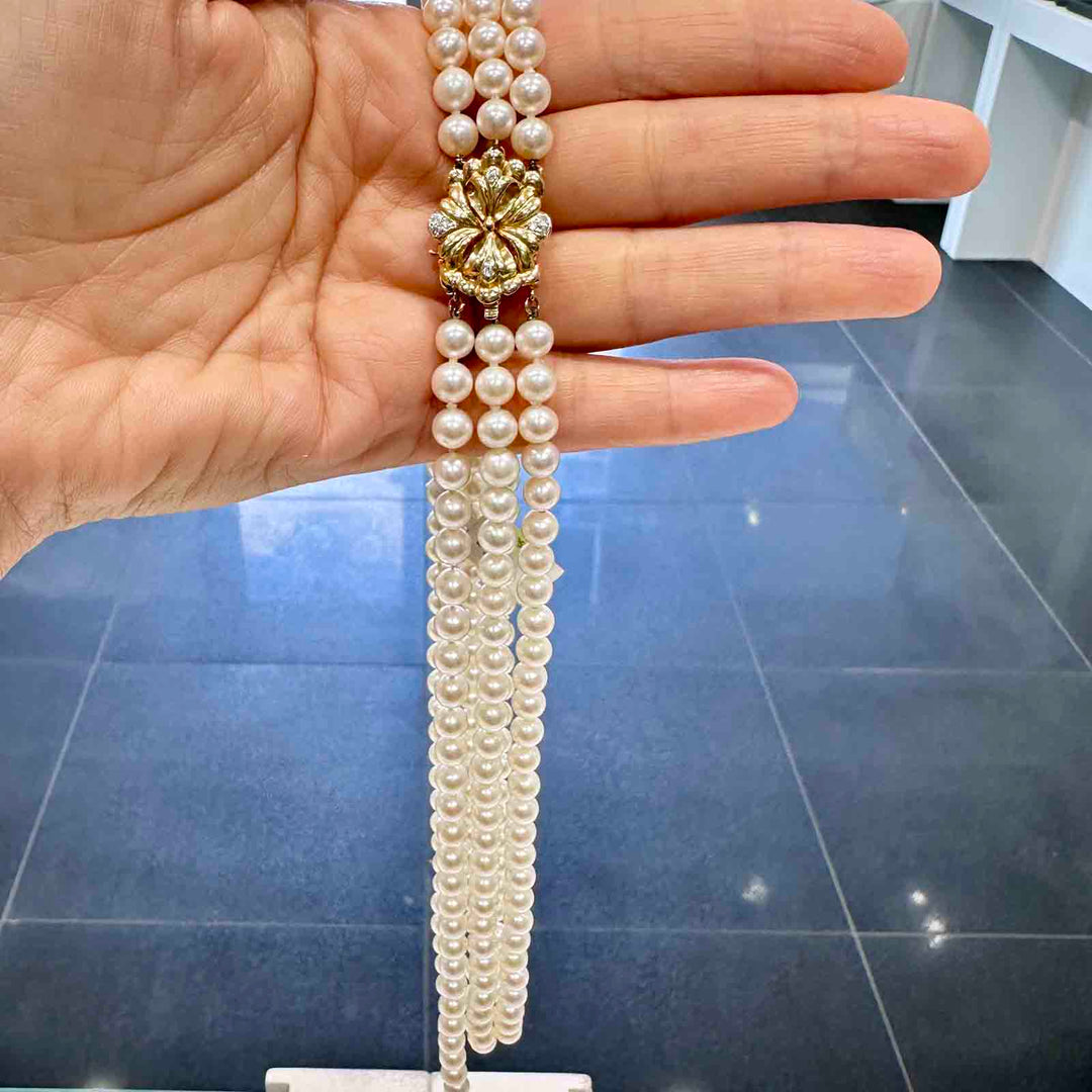 Three-strand freshwater pearl necklace with 6-5.4mm high luster white pearls and a 14k yellow gold clasp.