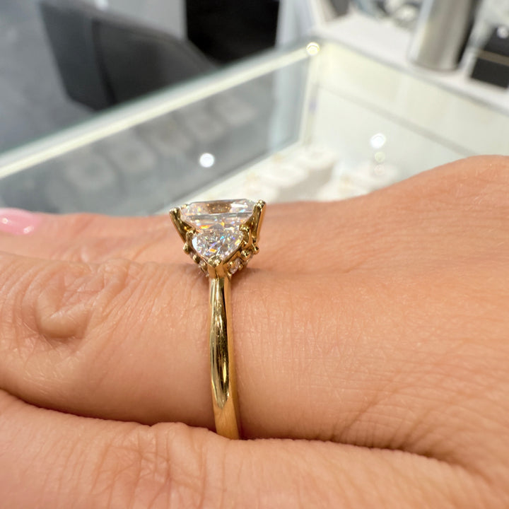 Radiant-cut moissanite ring with trillion side stones set in 14K yellow gold.