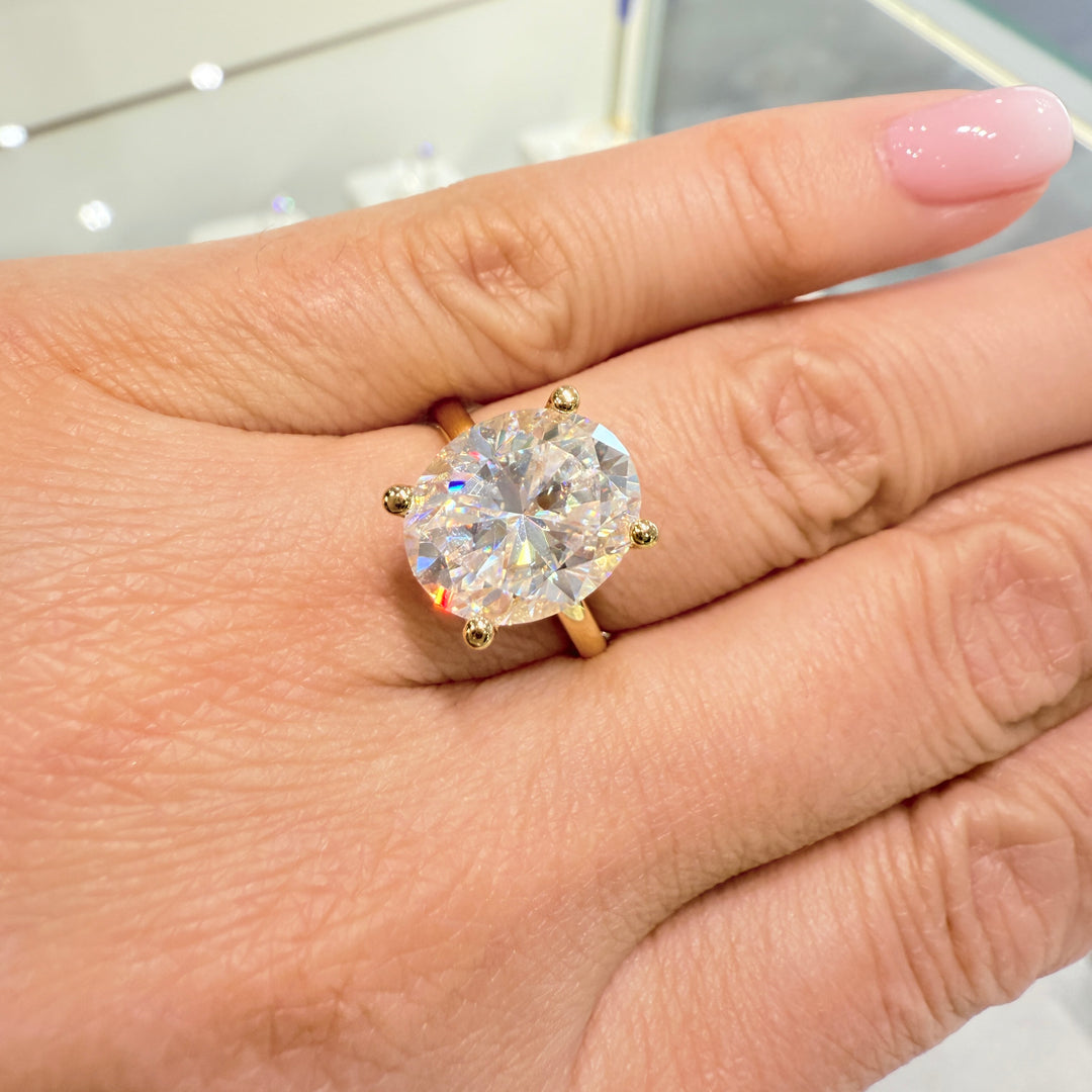 4 Ct oval moissanite engagement ring with hidden halo in 14K yellow gold.