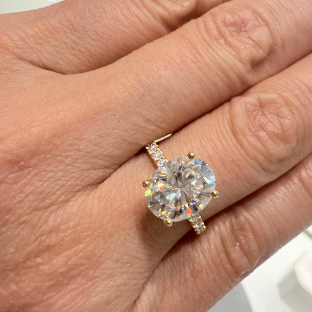 2.5 Ct oval moissanite engagement ring with pave band in 14K gold.