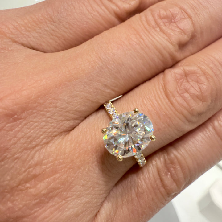 2.5 Ct oval moissanite engagement ring with pave band in 14K gold.