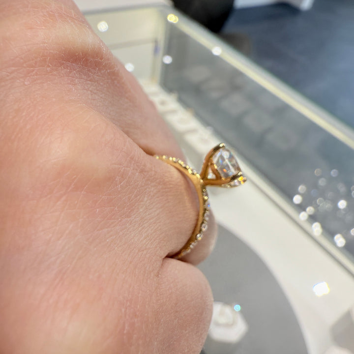 2.5 Ct oval moissanite engagement ring with pave band in 14K gold.