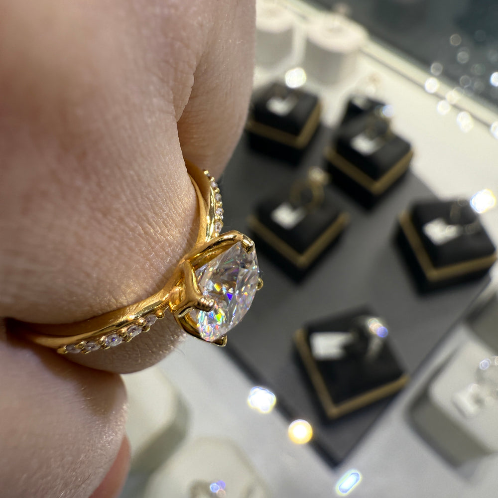 1.67CT round moissanite engagement ring with pave moissanite accents, set in 14K gold.