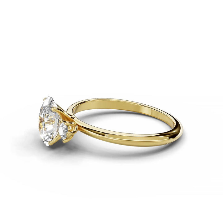 Oval diamond three-stone engagement ring in yellow gold.