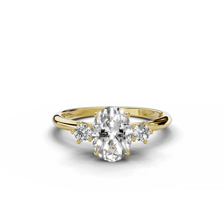 Oval diamond three-stone engagement ring in yellow gold.