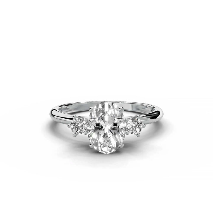 Oval diamond three-stone engagement ring, prong-set, low-profile, white gold.