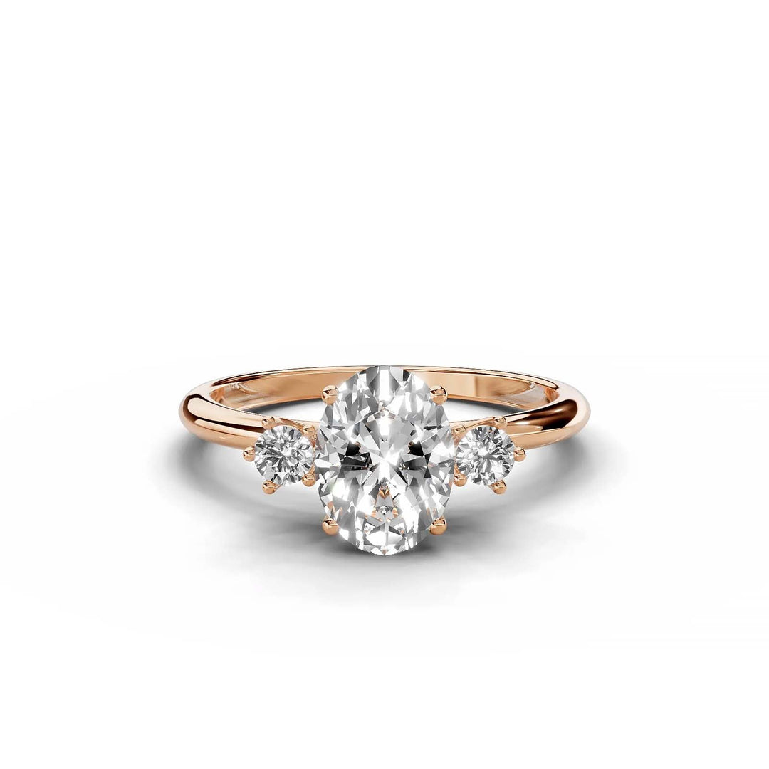 Oval diamond three-stone engagement ring in rose gold with round side stones.