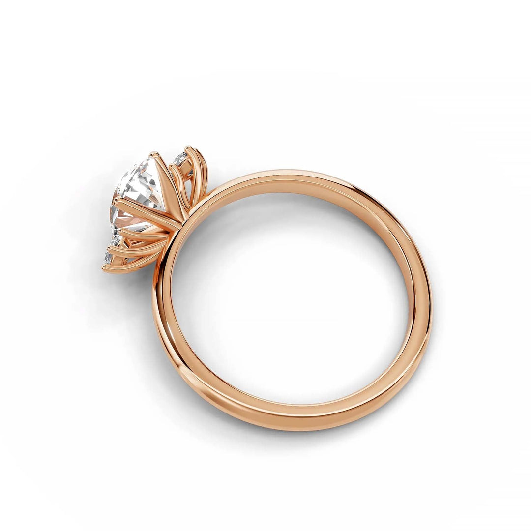 Oval diamond three-stone engagement ring in rose gold with round side stones.