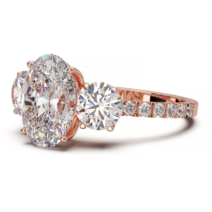 Three-stone engagement ring with 2-carat oval lab-grown diamond, round side stones, and pave band