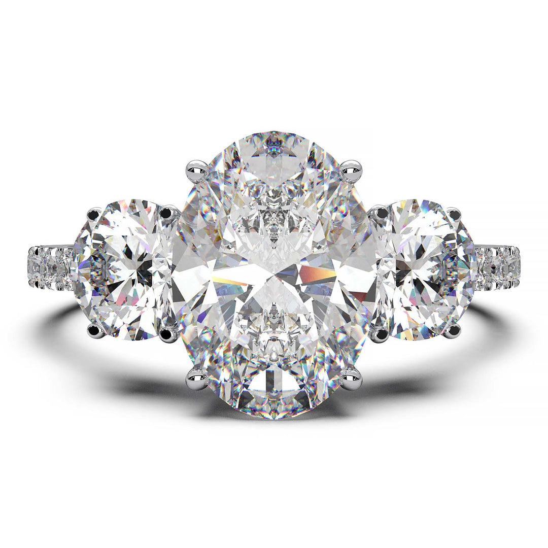 Three-stone engagement ring with 2-carat oval lab-grown diamond, round side stones, and pave band