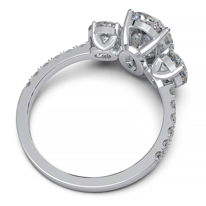 Three-stone engagement ring with 2-carat oval lab-grown diamond, round side stones, and pave band