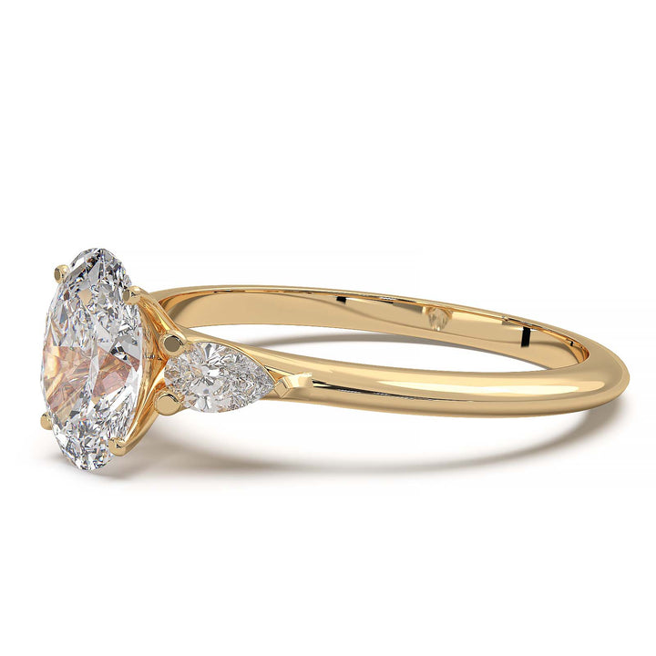 engagement ring featuring a 1 carat oval lab-grown diamond with pear-shaped side stones, held by unique cathedral-inspired prongs