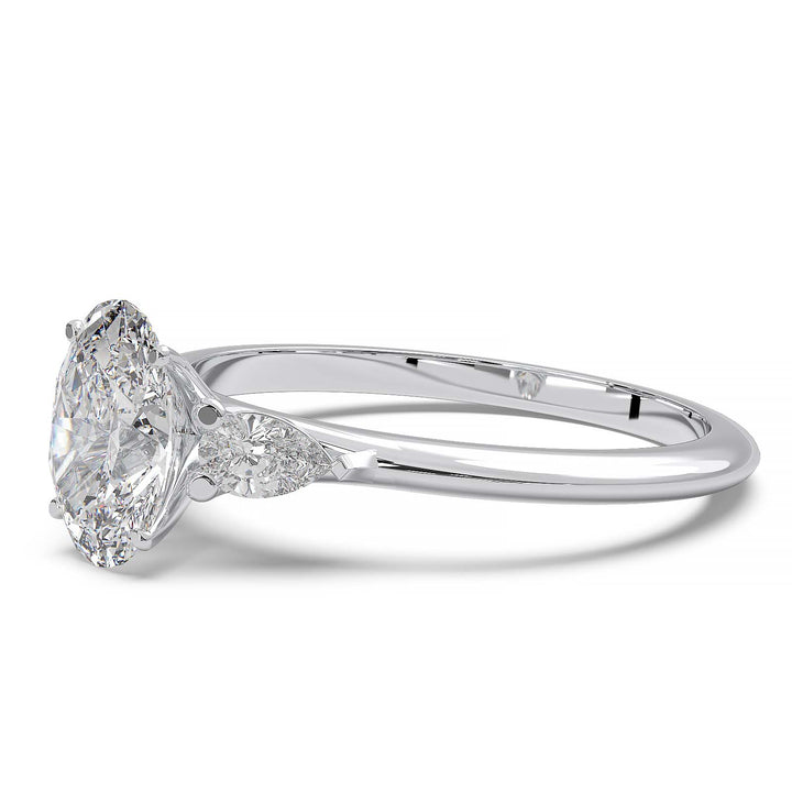 engagement ring featuring a 1 carat oval lab-grown diamond with pear-shaped side stones, held by unique cathedral-inspired prongs