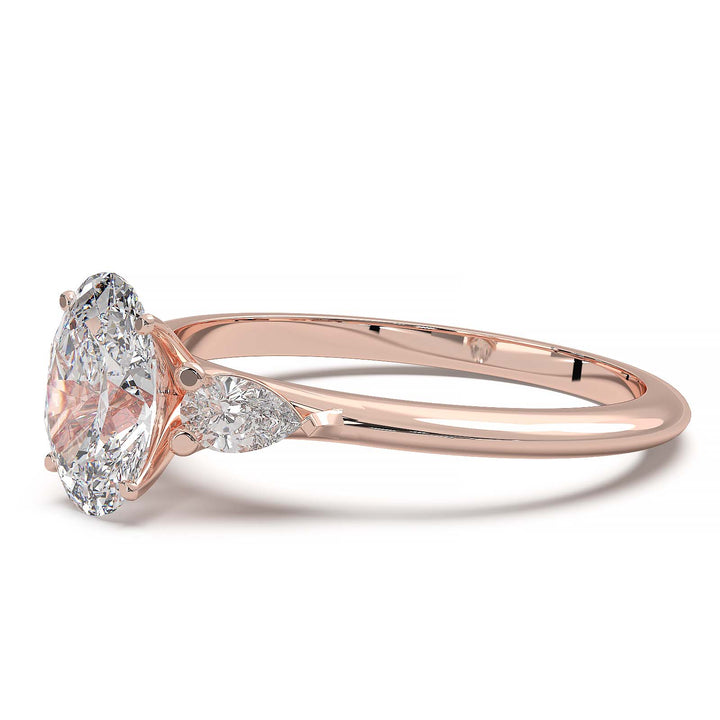 engagement ring featuring a 1 carat oval lab-grown diamond with pear-shaped side stones, held by unique cathedral-inspired prongs