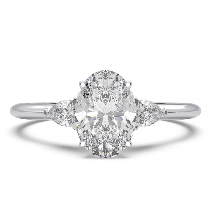 engagement ring featuring a 1 carat oval lab-grown diamond with pear-shaped side stones, held by unique cathedral-inspired prongs