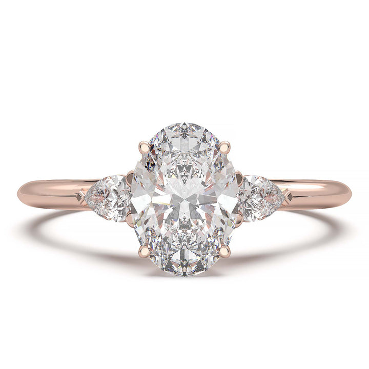 engagement ring featuring a 1 carat oval lab-grown diamond with pear-shaped side stones, held by unique cathedral-inspired prongs