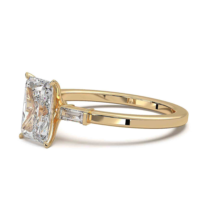 Radiant cut diamond three-stone engagement ring with 1.5 CT lab-grown center diamond and baguette side stones in a modern design.