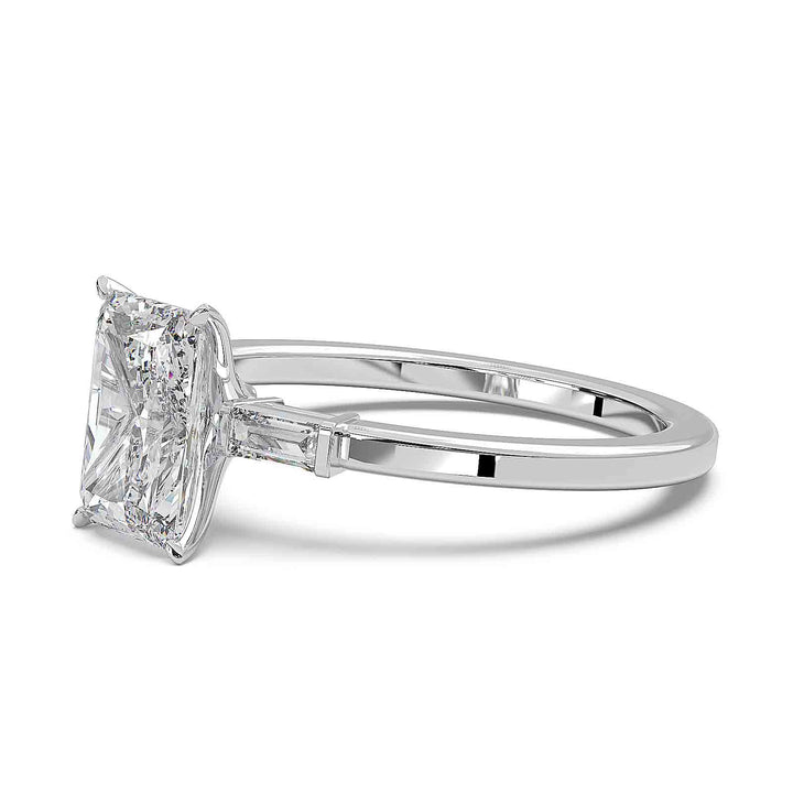 Radiant cut diamond three-stone engagement ring with 1.5 CT lab-grown center diamond and baguette side stones in a modern design.