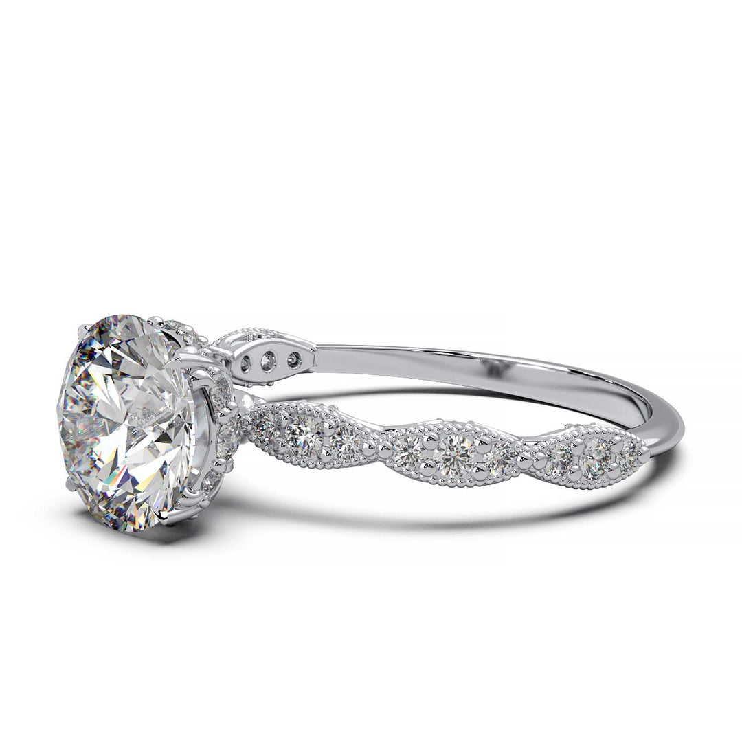A vintage-style engagement ring featuring a large, round-cut diamond set in a gold band. The band is intricately detailed with smaller diamonds embedded in an ornate, floral and milgrain pattern, adding elegance and sparkle.