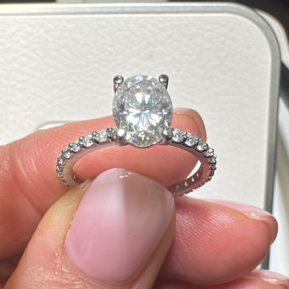 1 Ct oval moissanite engagement ring with pave band in 14K gold.