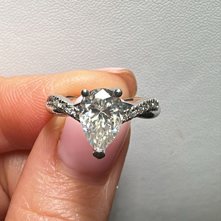 Moissanite pear-shaped engagement ring with 1.20CT center stone, accent moissanite, set in 14K gold.