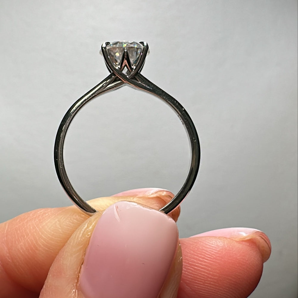 7.5mm round colorless moissanite solitaire ring in 14K gold.