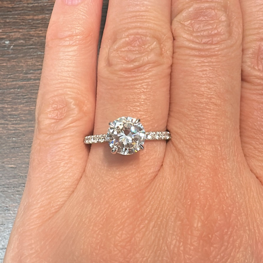 1.60 CT round moissanite engagement ring with hidden halo and moissanite accents in 10K gold.