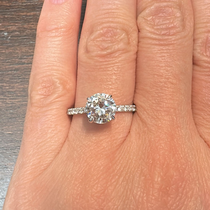 1.60 CT round moissanite engagement ring with hidden halo and moissanite accents in 10K gold.