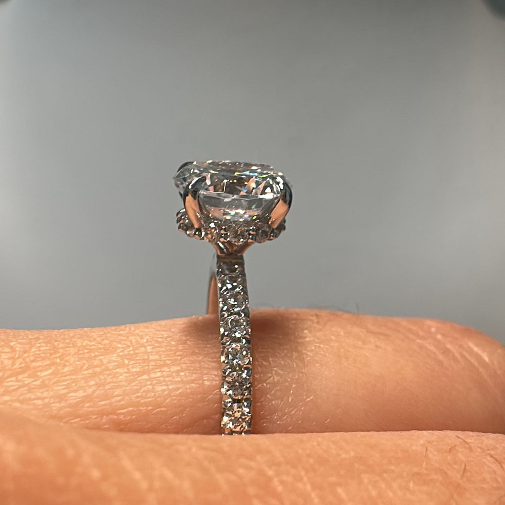 1.60 CT round moissanite engagement ring with hidden halo and moissanite accents in 10K gold.