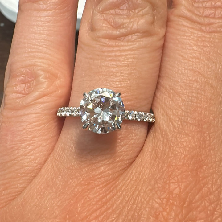 1.60 CT round moissanite engagement ring with hidden halo and moissanite accents in 10K gold.