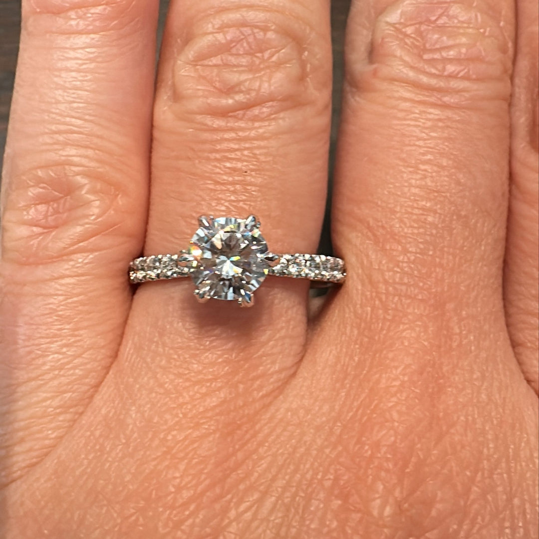 1 CT round moissanite engagement ring with small moissanite accents in 14K gold.