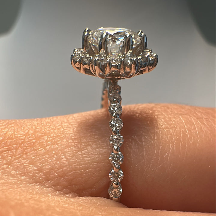1 CT round moissanite halo engagement ring with moissanite accents in 14K white gold.