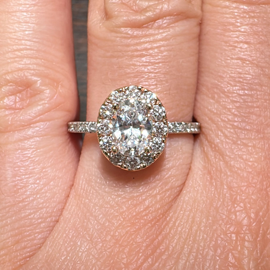 1 CT oval moissanite halo engagement ring in 14K gold with small diamonds.