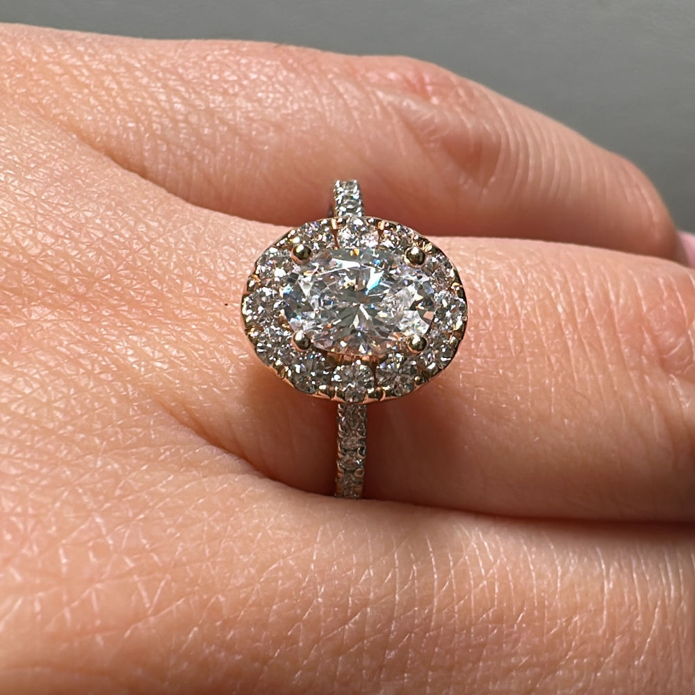 1 CT oval moissanite halo engagement ring in 14K gold with small diamonds.